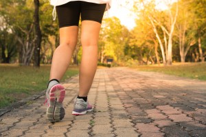 Fitness woman training and jogging in summer park, close up on running shoes. Healthy lifestyle and sport concept